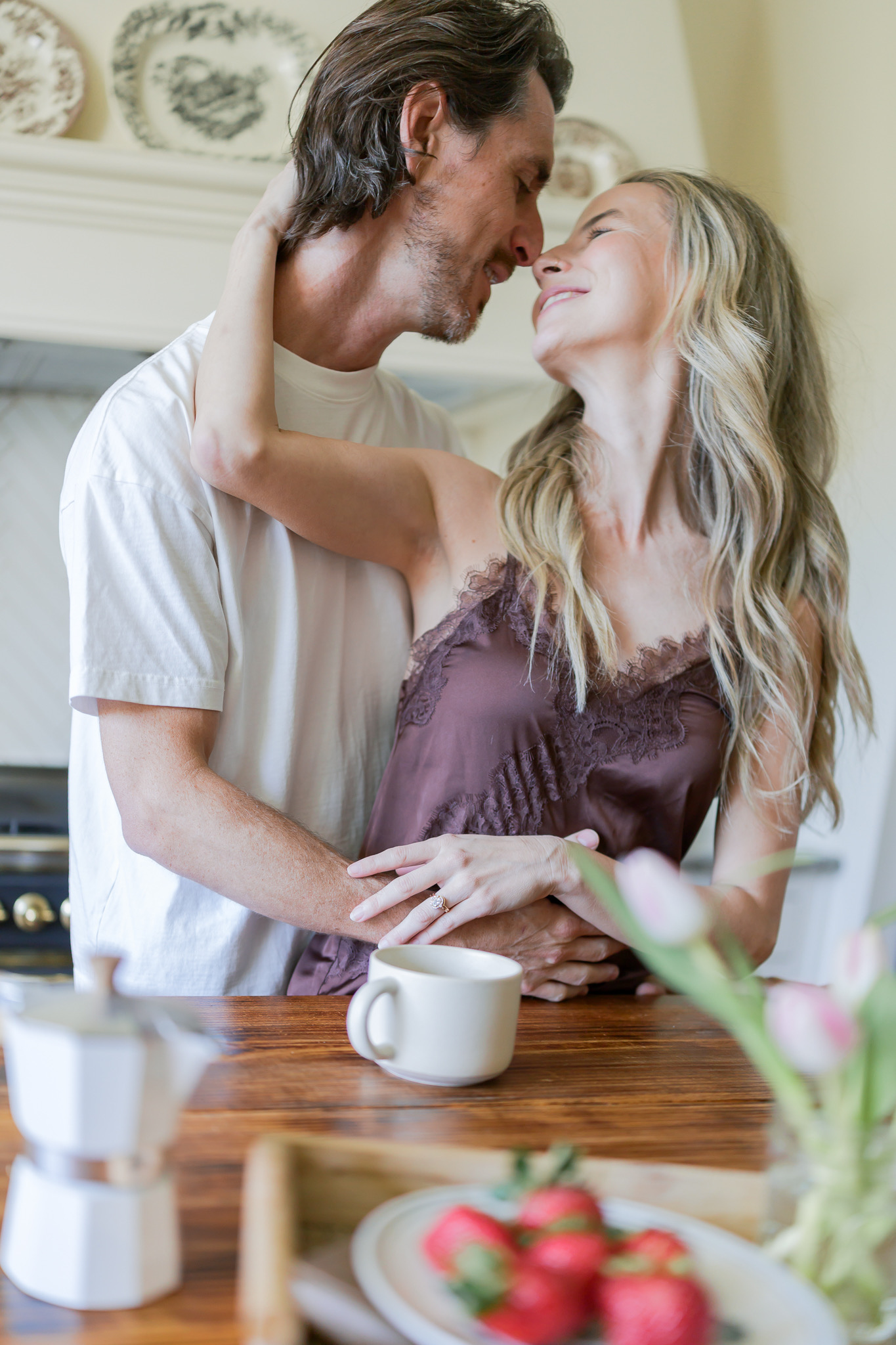 Couple sharing a nose-to-nose moment in a cozy kitchen